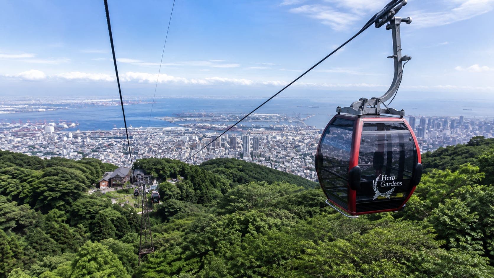 View from the Kobe Ropeway showing cityscape and Rokko Mountains in 2026.
