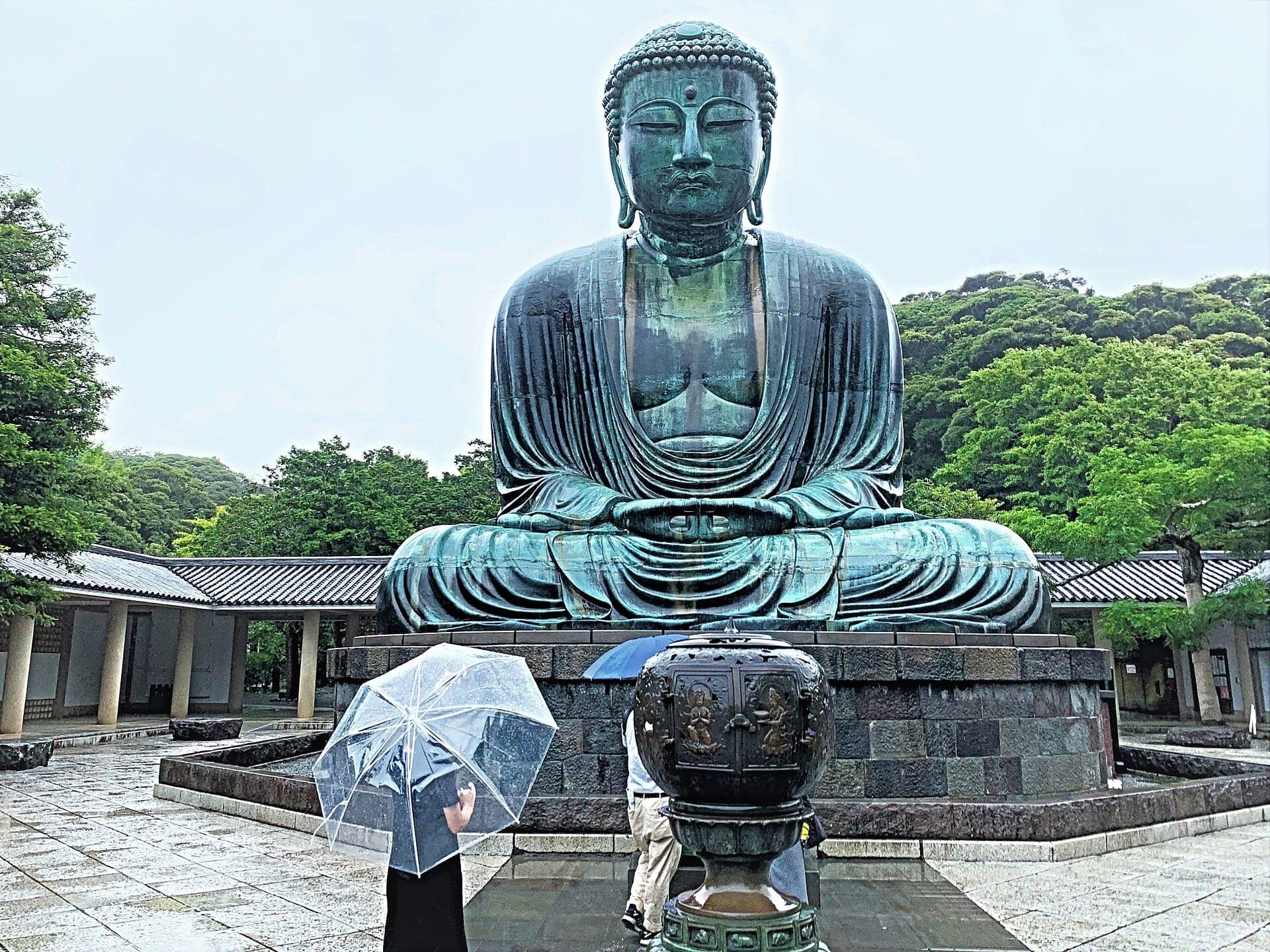 The bronze Great Buddha of Kotoku-in seated outdoors against a clear sky in Kamakura