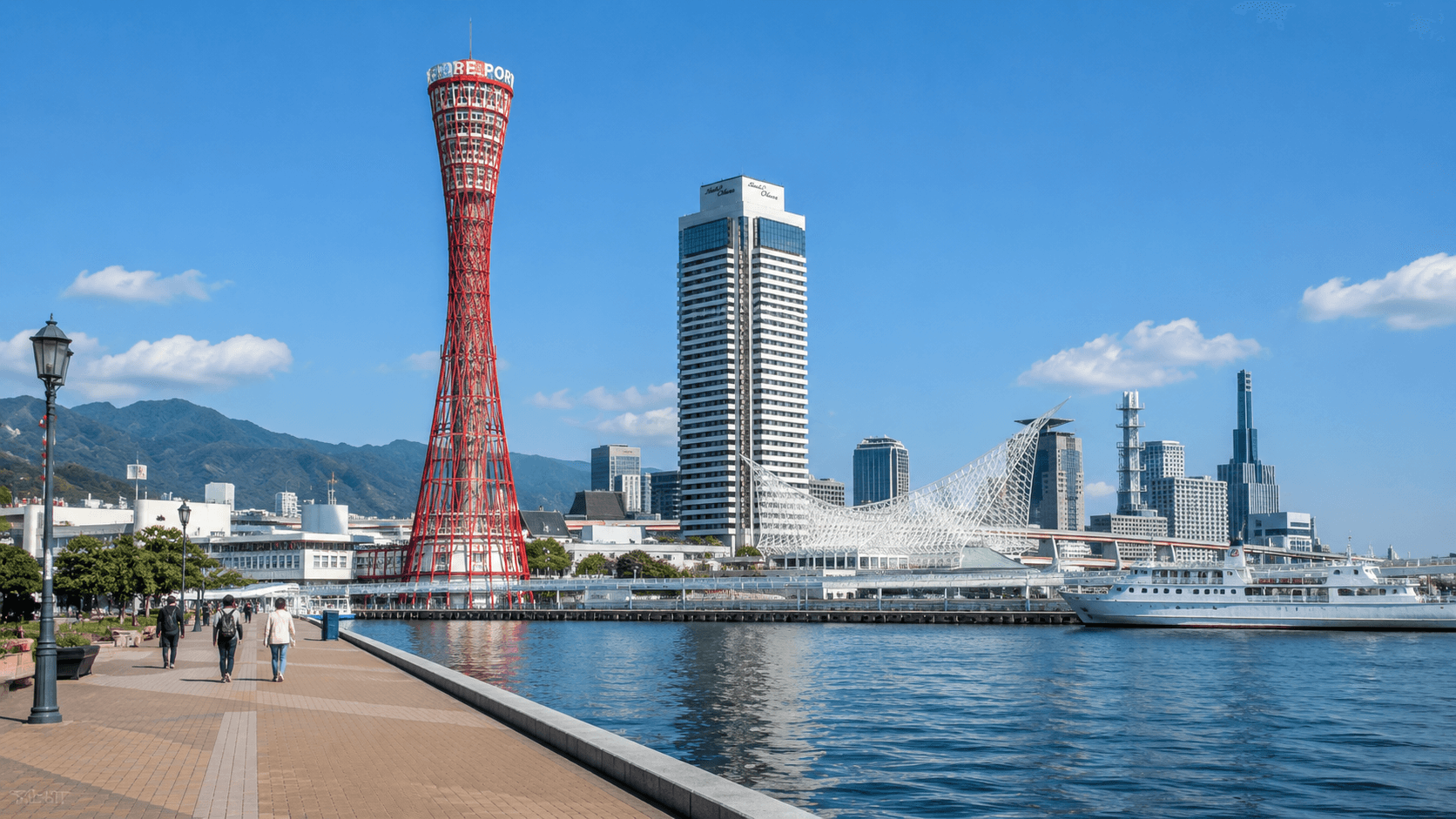 Kobe harbor at dusk with the illuminated Port Tower and city skyline reflecting on the calm waters of Osaka Bay